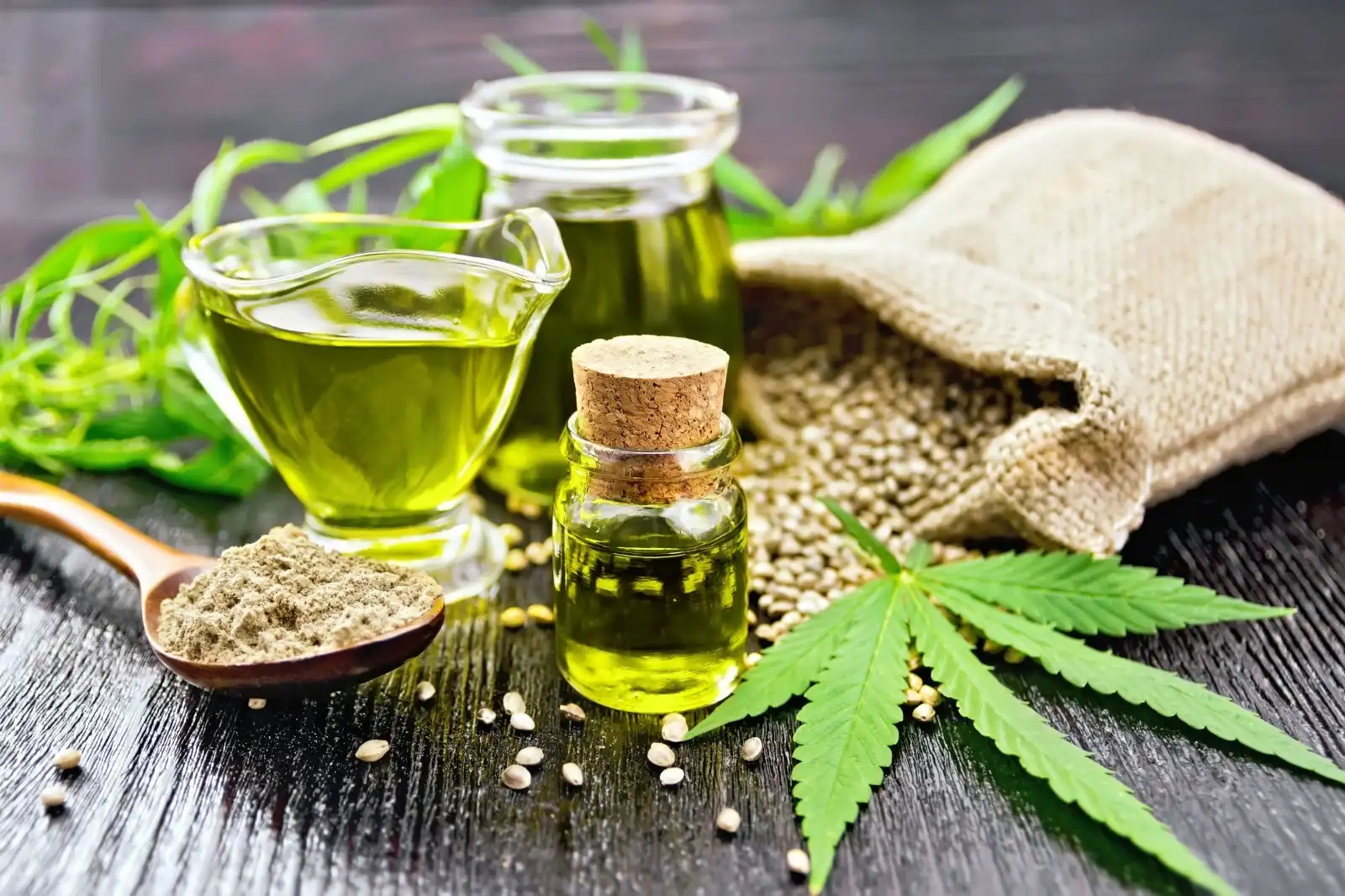Óleos e folhas de Cannabis medicinal sobre uma superfície de madeira